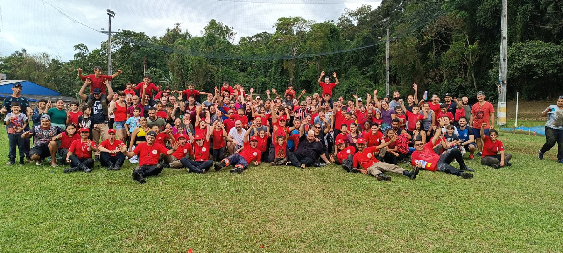 Turma do Bombeiro Xerife Mirim reunida no campo com instrutores e famílias, depois de uma missão na mata